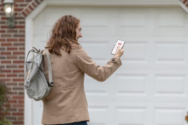 a woman looking at her phone outside the garage | Be Informed Home Inspections | Connectivity Dallas a woman looking at her phone outside the garage | Be Informed Home Inspections | Connectivity Dallas