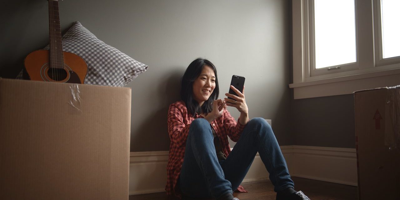 a girl sitting looking at her phone smiling | be Informed Home Inspections | moving made easy dallas fort worth