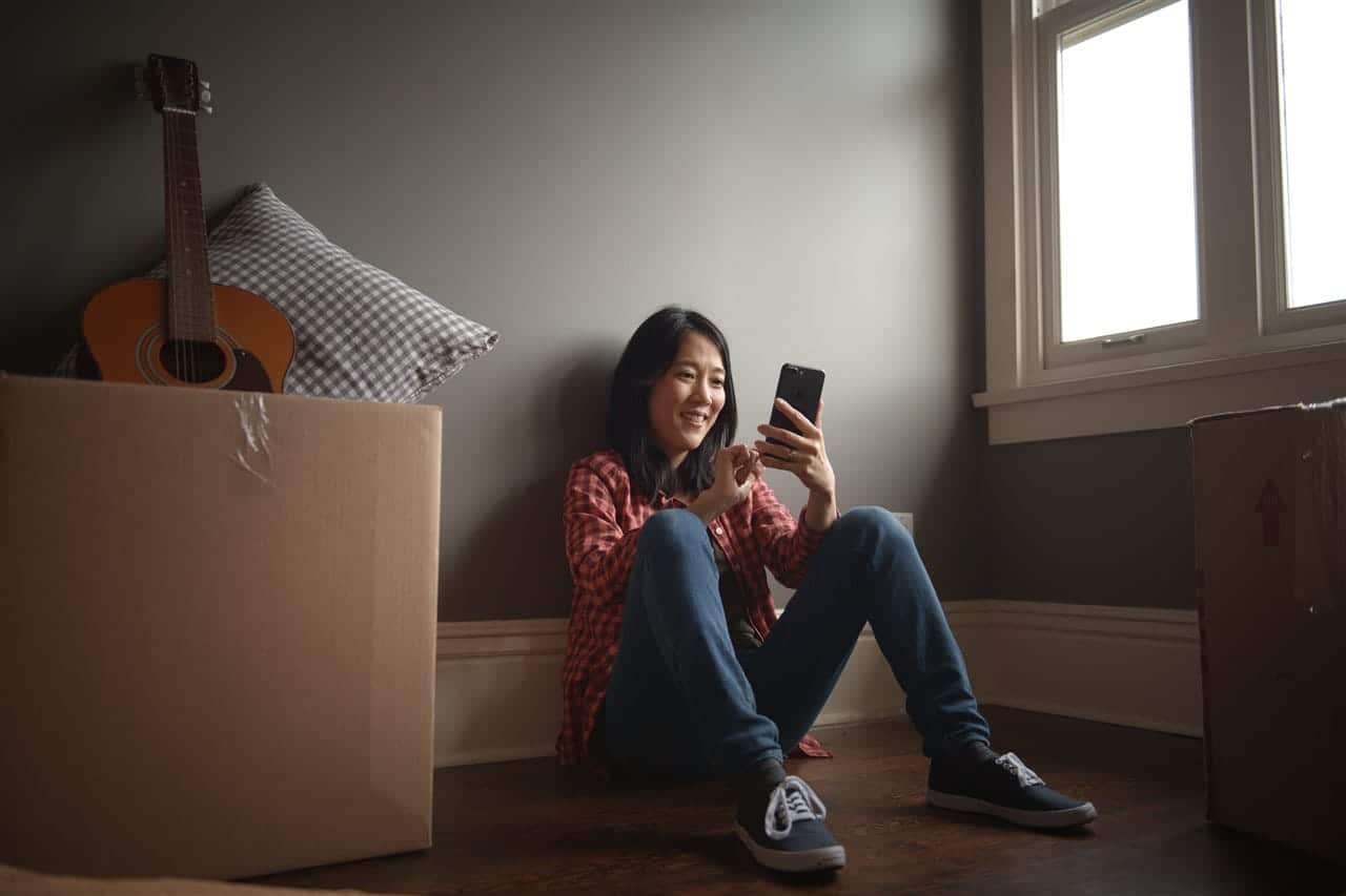 a girl sitting looking at her phone smiling | be Informed Home Inspections | moving made easy dallas fort worth a girl sitting looking at her phone smiling | be Informed Home Inspections | moving made easy dallas fort worth