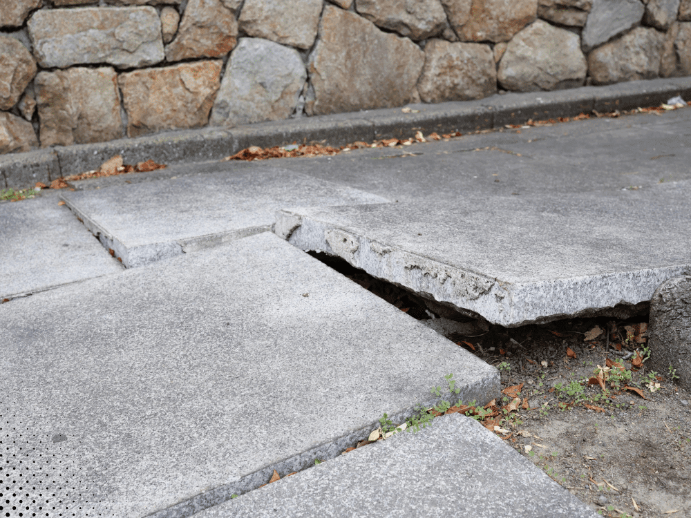 Uneven concrete slab caused by soil movement near a North Texas home